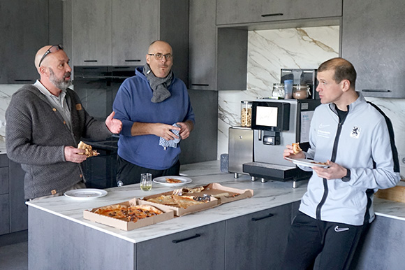 Alexander Hofmann (li.), Gerhard Neumann (Mitte) und Jonas Schittenhelm (re.) lassen sich die Pizza in der NLZ-Küche schmecken. Foto: Joachim Mentel