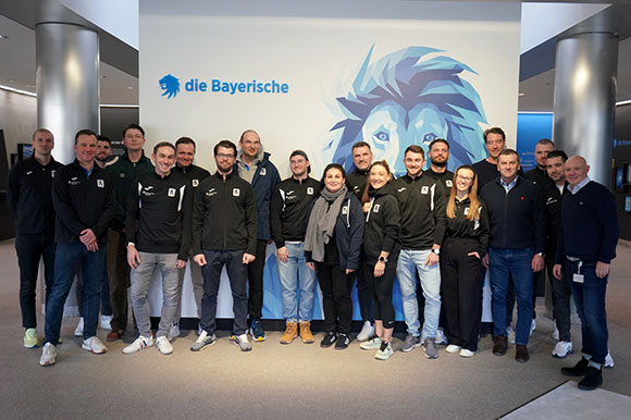 Gruppenbild zusammen mit Volker Rech (re.) im Eingangsbereich der Zentrale von Hauptsponsor und NLZ-Namensgeber die Bayerische. Foto: Joachim Mentel